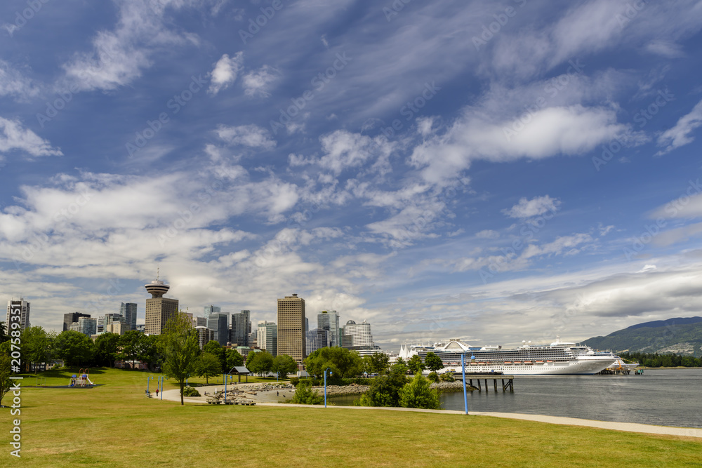 summer day in a megalopolis city park with skyscrapers, a blue sky with clouds, a white ship summer day in a megalopolis city park with skyscrapers, a blue sky with clouds, a white ship