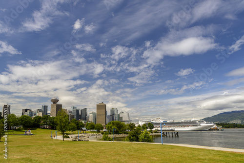 summer day in a megalopolis city park with skyscrapers, a blue sky with clouds, a white ship