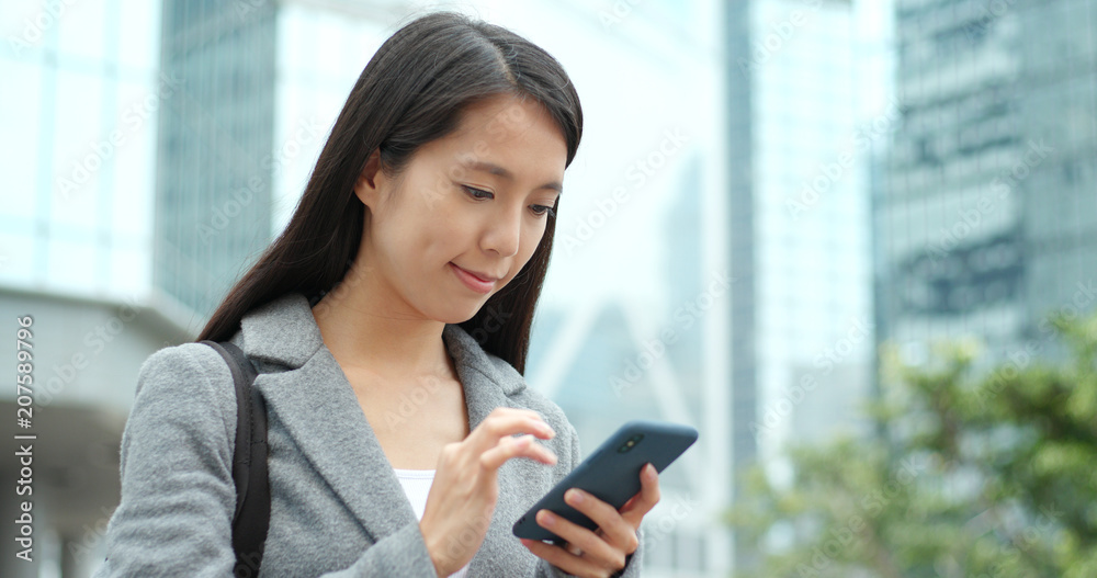 Business woman sending sms on cellphone