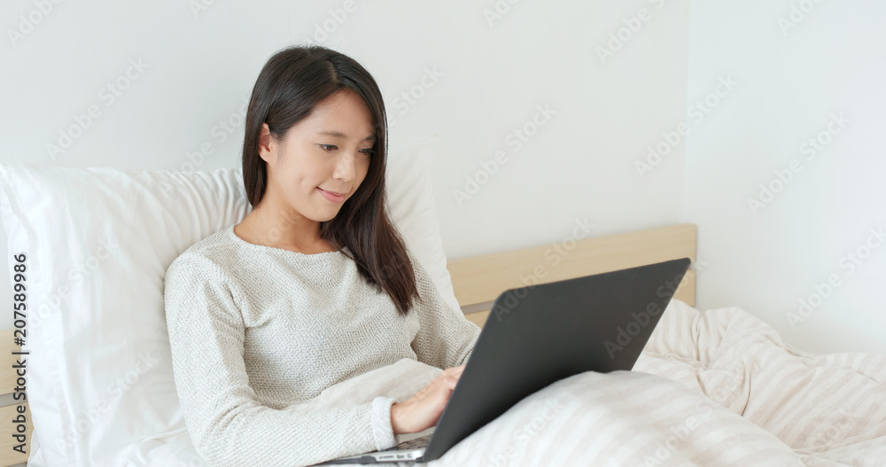 Woman working laptop computer on bed Woman working laptop computer on bed