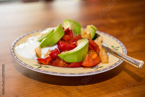 plate with fried vegetables and row avocado