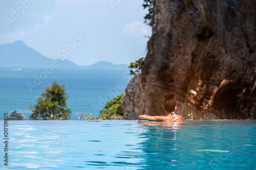 Woman relaxing in infinity swimming pool looking at view © freedom_naruk