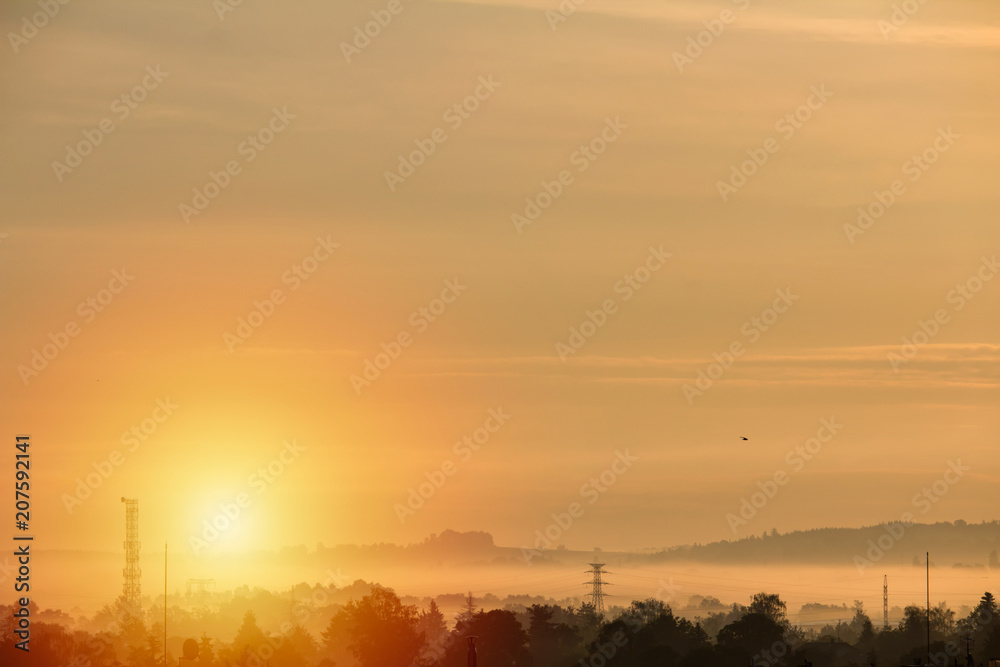 Orange sunrise over hills with mysty fog