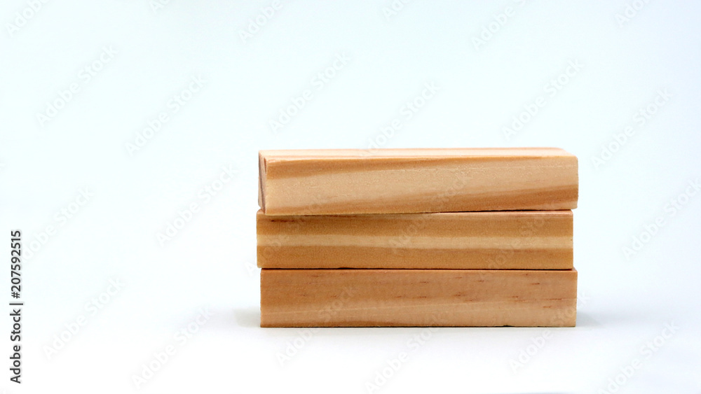 A pile of three wooden blocks on a bright background. A pile of three wooden blocks on a bright background.