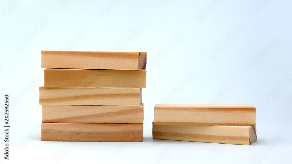 A pile of five wooden blocks beside a pile of two wooden blocks.