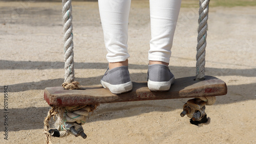 The back leg of a woman on a swing.