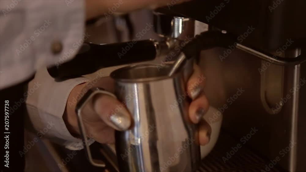 Barista whipping milk in a jar on a professional coffee machine Barista whipping milk in a jar on a professional coffee machine