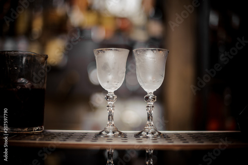 Obraz na plátne Two elegant cooled glasses arranged on the bar counter