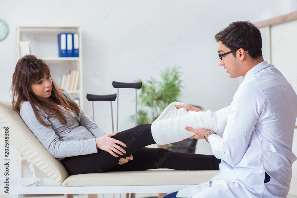 Doctor examining patient with broken leg Doctor examining patient with broken leg
