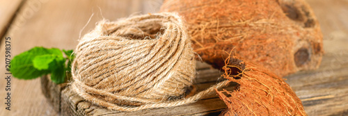 Rope of fiber coir and coconut shell on an old wooden table.