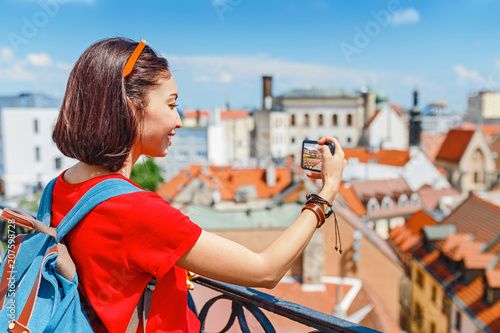 Photography Young woman taking a photo on her smartphone in Europe