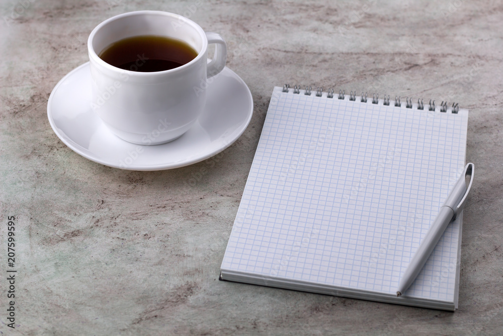 coffe cup and notebook on a marble background coffe cup and notebook on a marble background