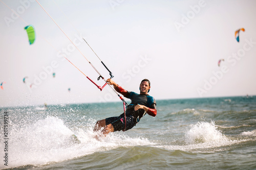 Kitesurfing Kiteboarding action photos man among waves quickly goes