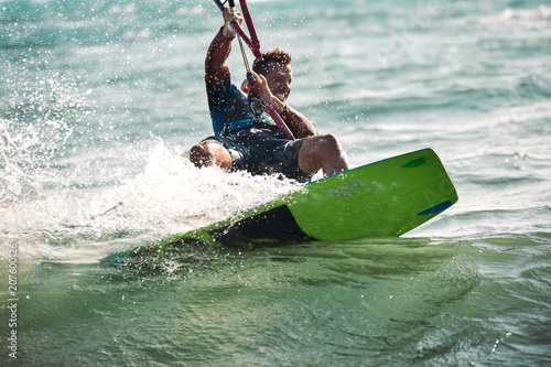 Kitesurfing Kiteboarding action photos man among waves quickly goes