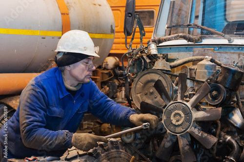 Photo of handsome service station worker repairing motor car