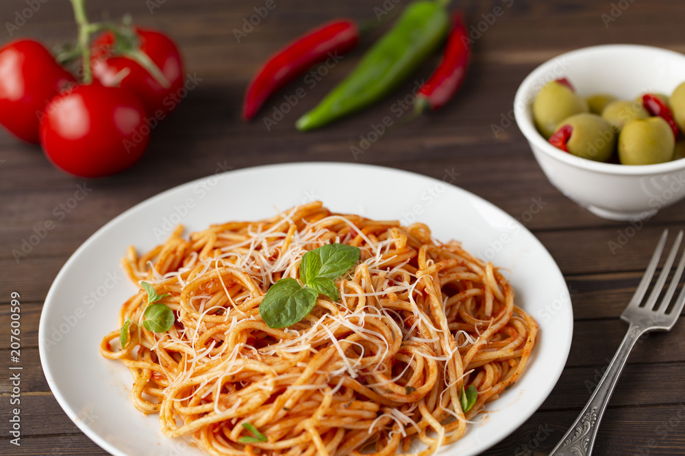 Spaghetti with tomato sauce in the dish on the wooden table Spaghetti with tomato sauce in the dish on the wooden table