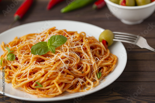 Spaghetti with tomato sauce in the dish on the wooden table