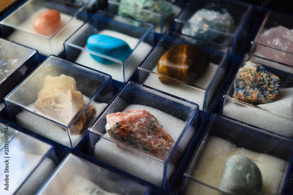 collection of minerals and precious stones in glass boxes