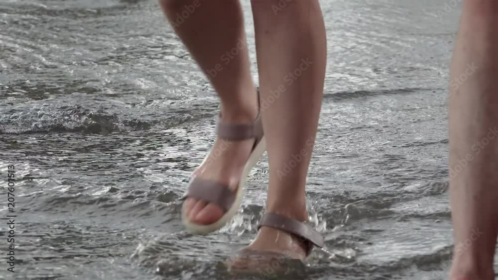 Girl cross ankle-deep water after the rain on a sidewalk. Girl cross ankle-deep water after the rain on a sidewalk.
