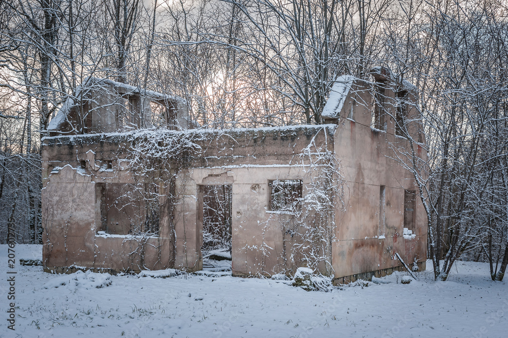 The lonely ruins of house. Old building standing in the snow. Winter season. Sunset. Latvia.