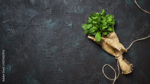 Fresh meadow mint in a beam, dark background, top view