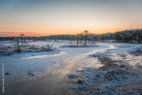 Ice path through marsh. Beautiful winter evening and cold frosty winter sunset. Selective focus. Kakerdaja nature trail. Estonia.. © Regina
