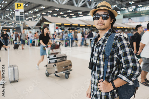 Asian man bag pack tourist with camera in airport.