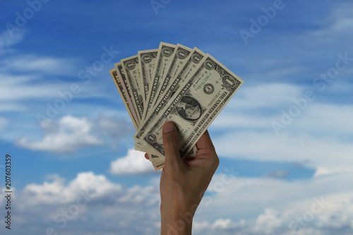 Pay the US dollar on sky and cloud background