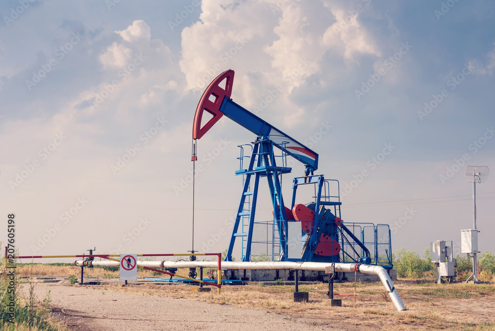 Working oil rig in a cornfield