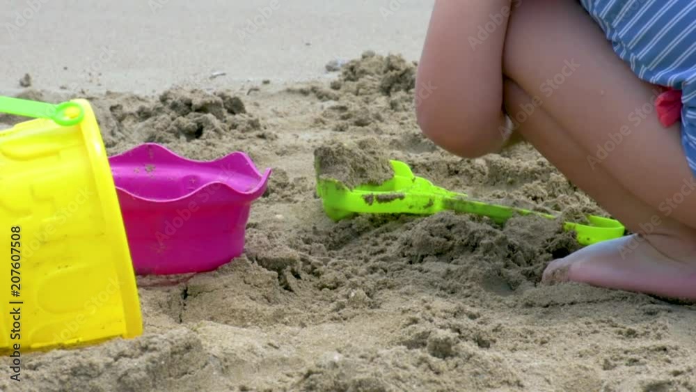 Closeup of a girl building castles in the sand Closeup of a girl building castles in the sand