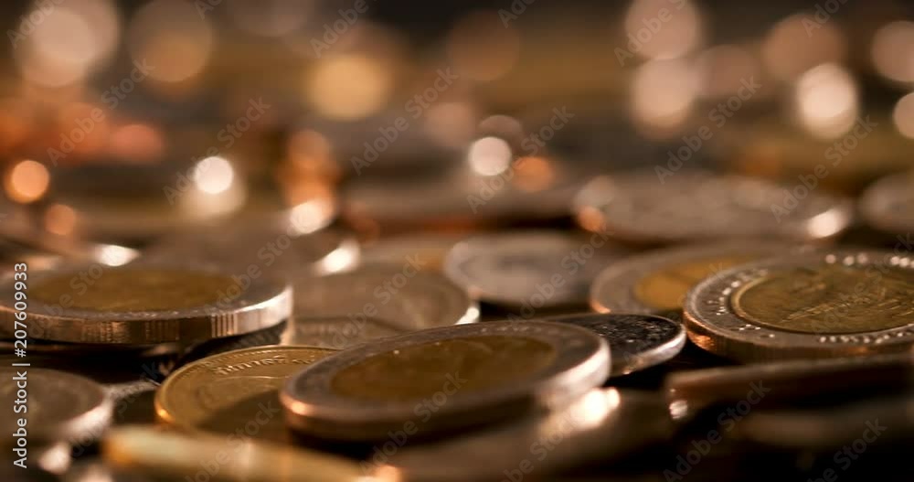 pan shot of close up money coin stacking on the floor in dark light , business and financial for money saving or the investment background concept , extremely close up and shallow DOF pan shot of close up money coin stacking on the floor in dark light , business and financial for money saving or the investment background concept , extremely close up and shallow DOF