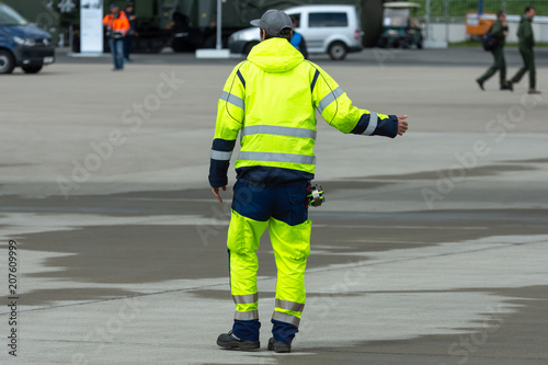 A flight safety officer in light-reflecting clothing on the airfield.