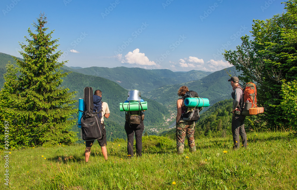 Group of tourists with large backpacks are on mountain Group of tourists with large backpacks are on mountain
