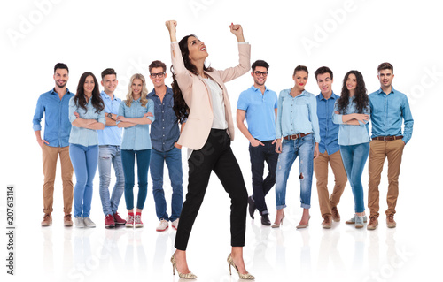 excited businesswoman celebrating while standing in front of her team