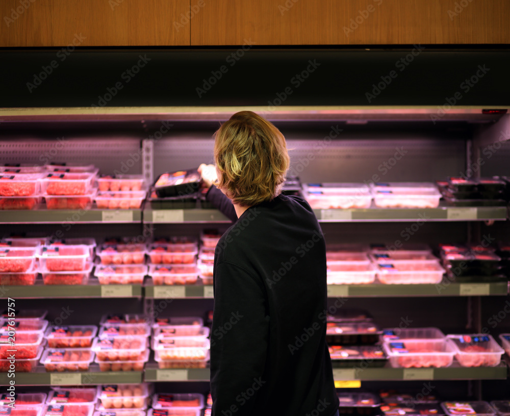 men purchasing a packet of meat at the supermarket 