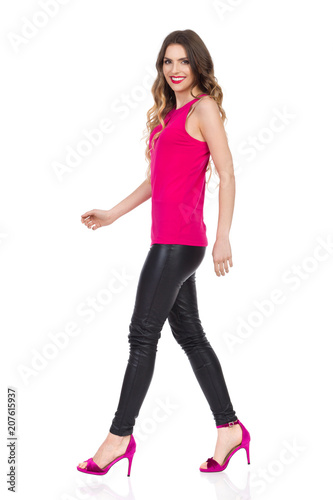 Smiling Beautiful Woman Is Walking In Pink High Heels. Side View.