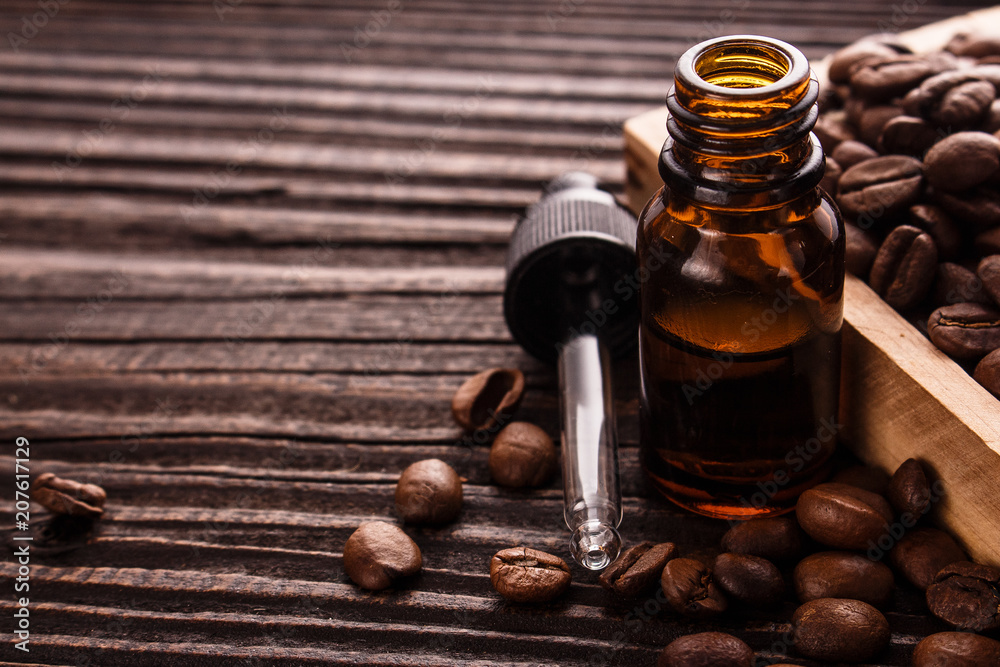 essential oil of coffee beans on a wooden background