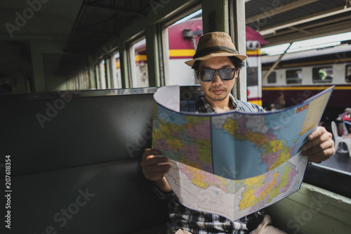 Asian man bag pack tourist with map in railway station at Thailand.