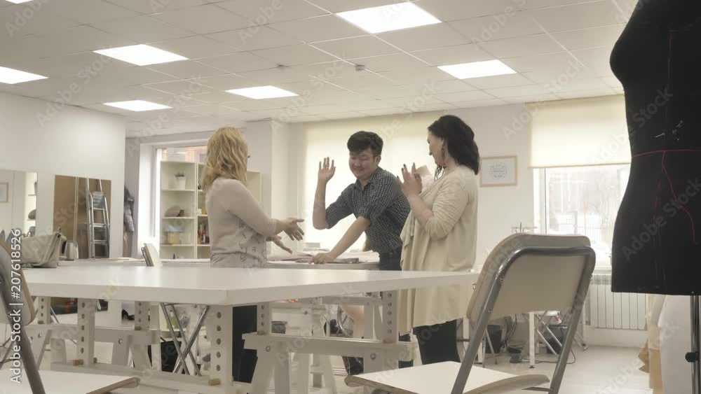 A team of designers creates clothes in the sewing studio. team high five A team of designers creates clothes in the sewing studio. team high five