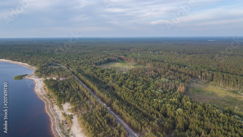Fototapeta Naklejka Na Ścianę i Meble -  Aerial view of winding road along coastline through lush green forest