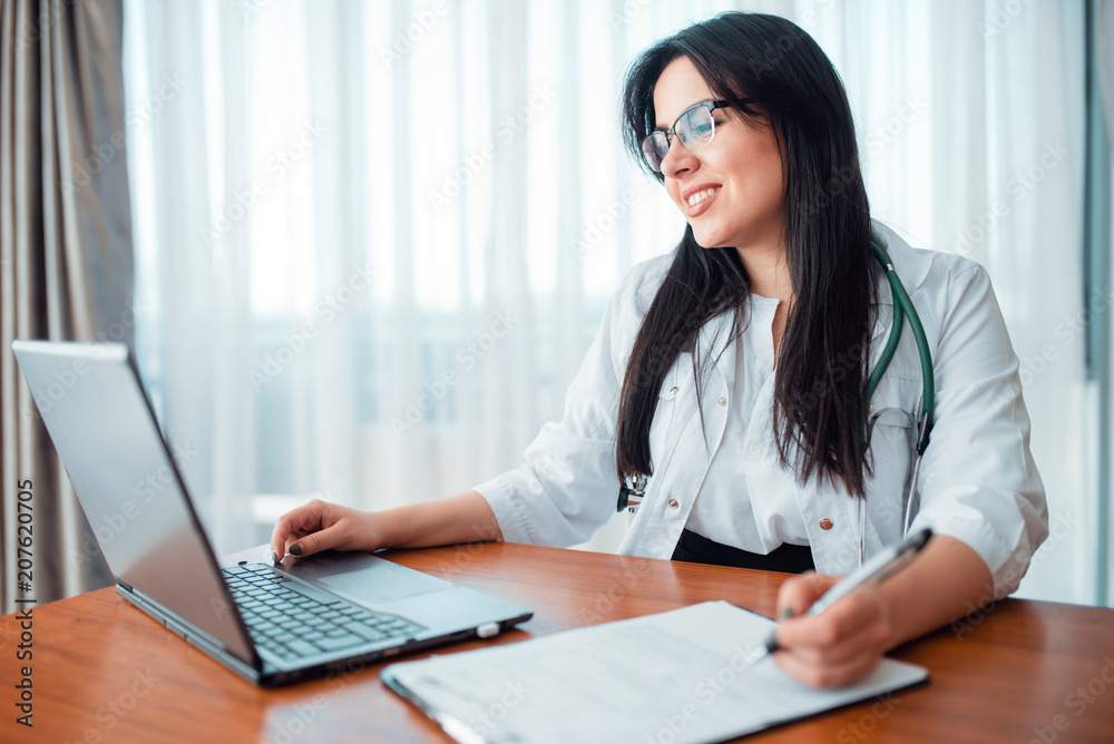 Family doctor concept, specialist sits at laptop Family doctor concept, specialist sits at laptop