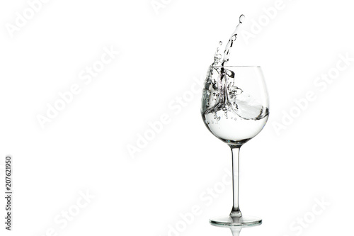 Clear water splashing in the wine glass. horizontal with space for text