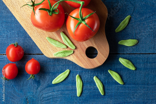 Tomatoes on wooden board with pasta