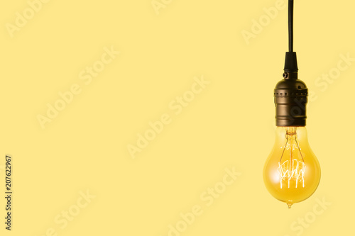 Edison light bulb on yellow background. space for text