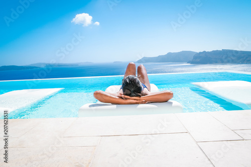 woman at an infinity pool looking out over the caldera of Santorini Greece, luxury vacation