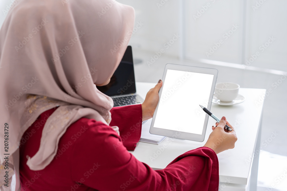 Beautiful young muslim woman using tablet mockup in modern white office ...