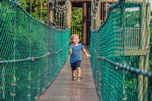 The boy is running on a suspension bridge in Kuala Lumpur, Malaysia photo