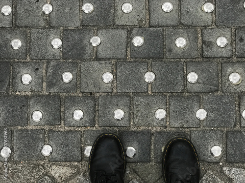 Фотография Feet standing on tactile paving steel studs