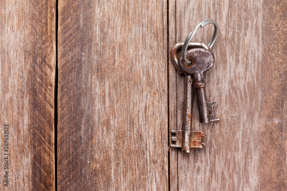 old keys on a brown wooden background