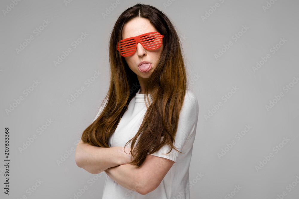 Portrait of emotional beautiful plus size model in sunglasses standing in studio looking in camera posing with crossed arms Portrait of emotional beautiful plus size model in sunglasses standing in studio looking in camera posing with crossed arms